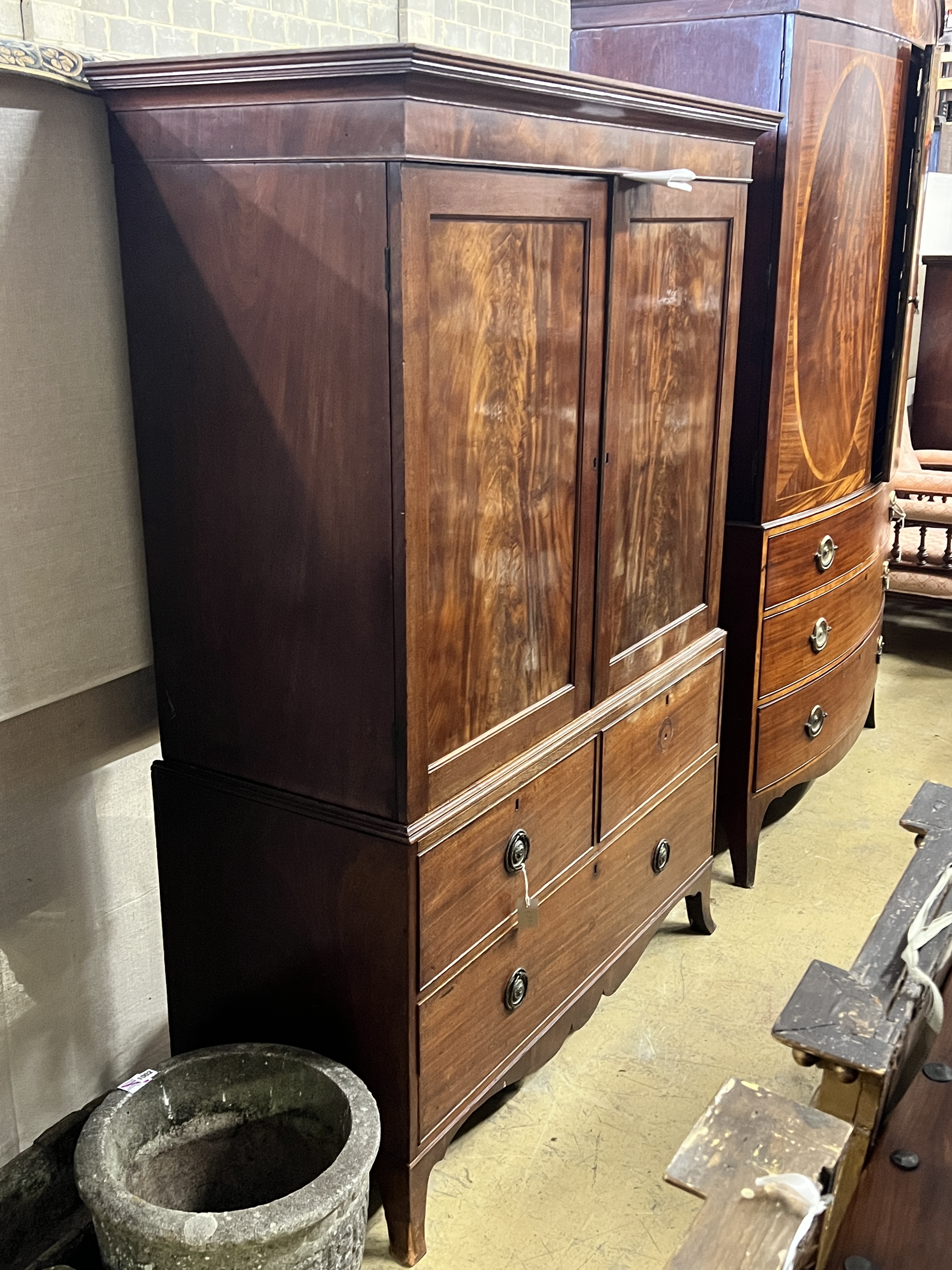 A George III mahogany linen press converted to a hanging wardrobe with part dummy drawer front, width 127cm, depth 54cm, height 178cm